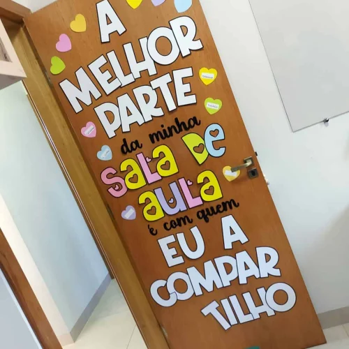 Porta decorada com frase motivacional e corações coloridos.