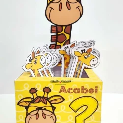 Giraffe de pelúcia com óculos e expressão divertida para atividades educativas.