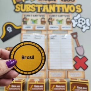 Material pedagógico interativo chamado Caça aos Substantivos, com moedas ilustrativas, baús de tesouro e cartazes para ensinar gramática de forma divertida em sala de aula.