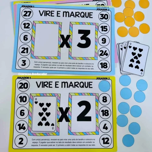 Jogo educativo de multiplicação com cartas e marcadores coloridos.
