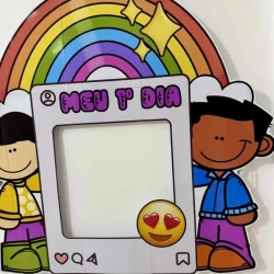 Decoração colorida com arco-íris, personagens e quadro para fotos.