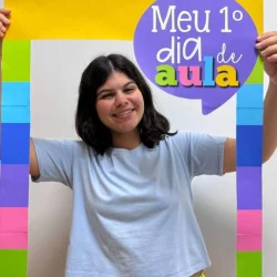 Jovem sorridente segurando moldura de volta às aulas com cores vibrantes.