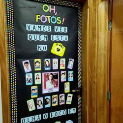Painel com fotos de alunos e professores na escola.