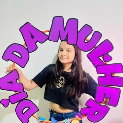 Menina segurando quadro com mensagem 'DAMA MUJER' em celebração do Dia da Mulher.