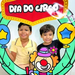 Crianças com decoração de circo e bambolês para o Dia do Circo.