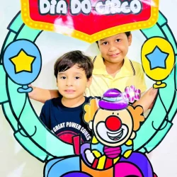 Crianças com decoração de circo e bambolê em celebração do Dia do Circo.