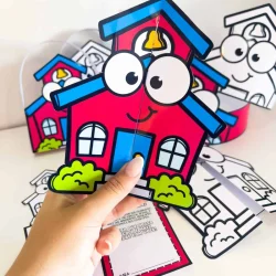Lembrancinha de casa de escola com olhos e sorriso, feita de papel colorido.