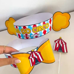 Decoração de festa infantil com tema de circo, incluindo chapéus e painel colorido.
