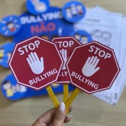 Luva com sinal de stop contra bullying, símbolo de combate ao bullying escolar.
