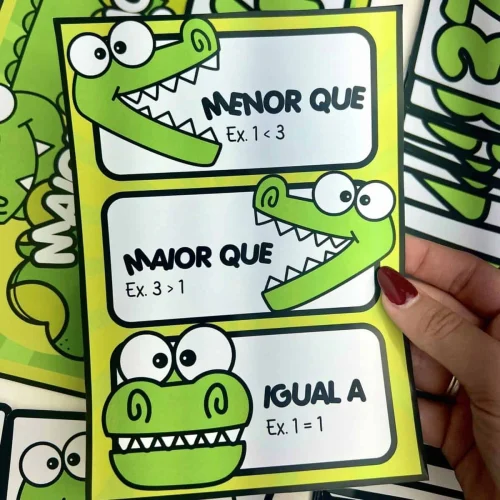 Cartões ilustrados com crocodilos e expressões de comparação numérica.