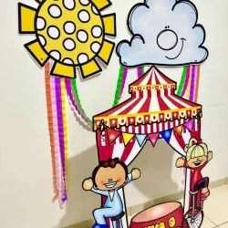 Decoração de circo com nuvem, sol, crianças e carrinho colorido.