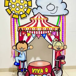 Moldura gigante de circo com crianças sorrindo e decoração colorida.
