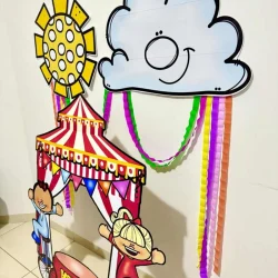 Moldura gigante de circo com nuvem sorridente e crianças brincando.