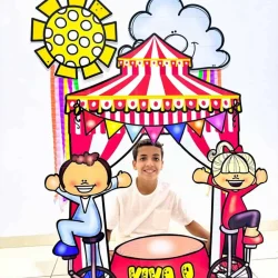 Moldura gigante de circo com crianças e decoração colorida.