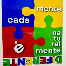 Mural colorido com peças de quebra-cabeça e mensagem sobre autismo e mente.