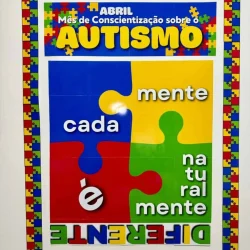 Mural colorido sobre autismo com peças de quebra-cabeça e mensagem educativa.
