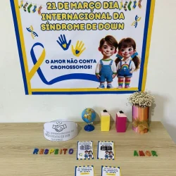 Painel comemorativo do Dia Internacional da Síndrome de Down com crianças e símbolos coloridos.