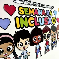 Cartaz com personagens de desenho animado promovendo a inclusão escolar.