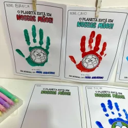 Mãos pintadas com cores diferentes e desenhos de crianças para conscientização ambiental.