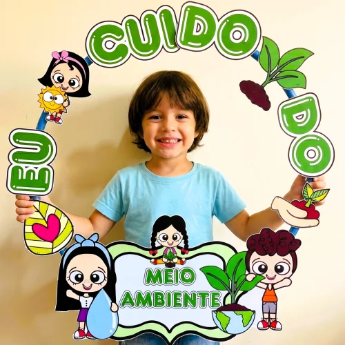 Criança segurando quadro com tema de meio ambiente e personagens divertidos.