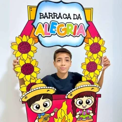 Criança em barraca decorada com tema de Festa Junina e alegria.