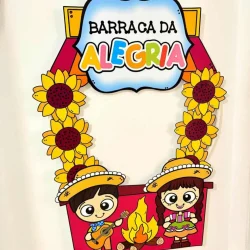 Decoração de Festa Junina com barraca colorida e crianças brincando.
