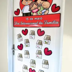 Decoração de porta com tema do Dia da Família e desenhos de casas e corações.