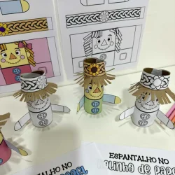 Espantalho de papel feito à mão com detalhes coloridos e chapéu de palha.