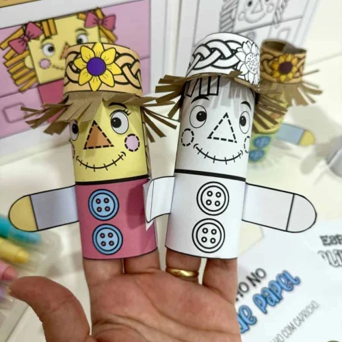 Espantalho de papel artesanal com detalhes coloridos e chapéu de palha.