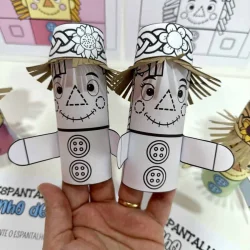 Espantalho de papel artesanal com chapéu de palha e rosto desenhado.