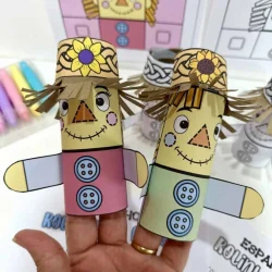 Espantalho de papel artesanal com chapéu decorativo e rosto sorridente.