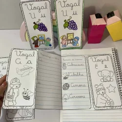 Cartões e caderno com atividades de vogais cursivas para crianças.