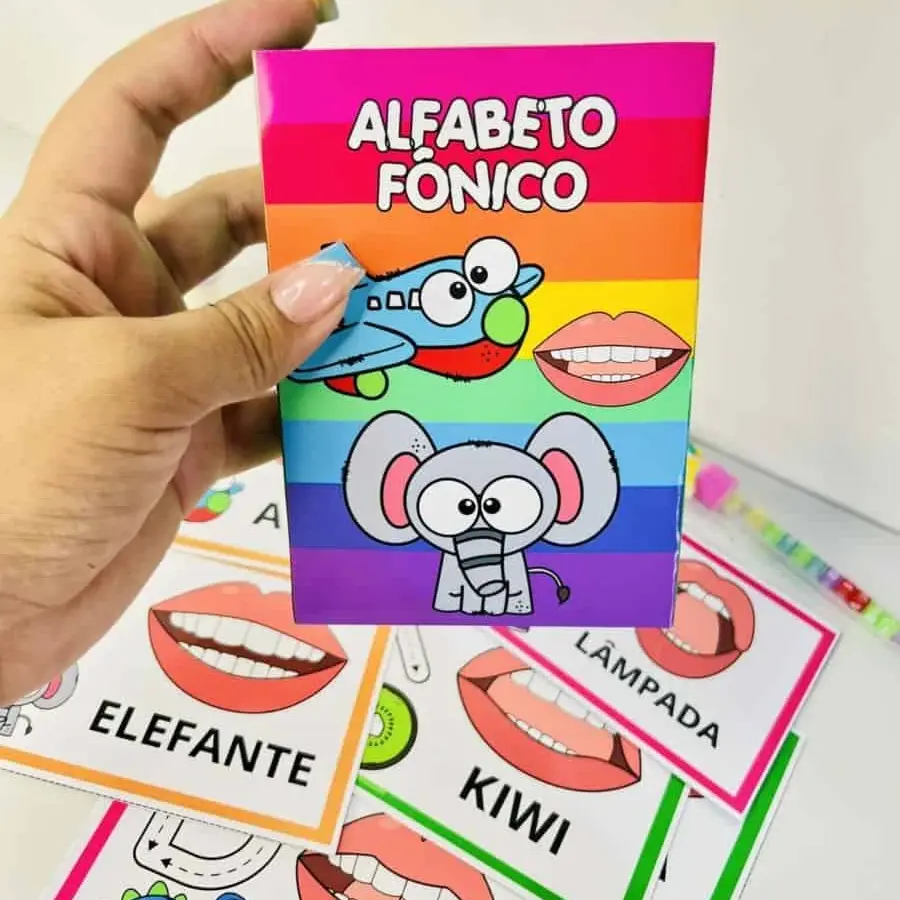 Cartilha de alfabeto fônico com desenhos de animais e objetos.