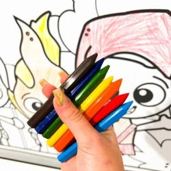 Criança segurando marcadores coloridos em frente a desenho de folclore brasileiro.