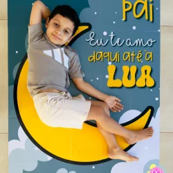 Criança no painel do Dia dos Pais com tema da lua e estrelas.