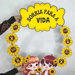 Arco decorativo com girassóis e personagens com mensagem de esperança.