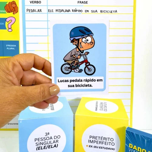 Imagem de dado com verbos Pedalar e Estudar para ensino de português.