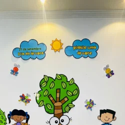 Painel educativo com tema Dia da Árvore e desenhos de crianças e insetos.