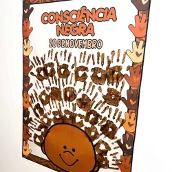 Cartaz com mãos pintadas e rosto sorridente para o Dia da Consciência Negra.