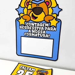 Cartaz de formatura com urso usando capelo e mensagem de contagem regressiva.