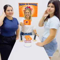 Três estudantes participando de atividade educativa Passa ou Repassa.