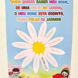 Painel com nomes de crianças em pétalas de flor para atividade educativa.