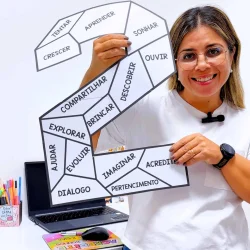 Mulher sorridente segurando um mosaico com palavras de aprendizagem.