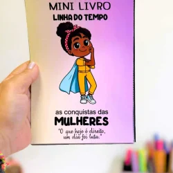 Caderno com ilustração de uma mulher heroína e título em português.