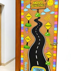Porta decorada com tema de volta às aulas e mensagens motivacionais.