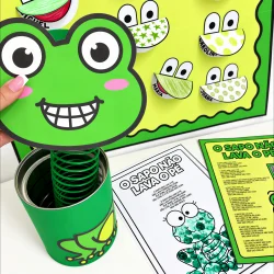 Brinquedo de sapo com rosto sorridente e óculos, ideal para atividades educativas.