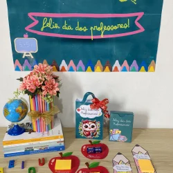 Decoração de Dia dos Professores com painel, lembrancinhas e itens escolares.